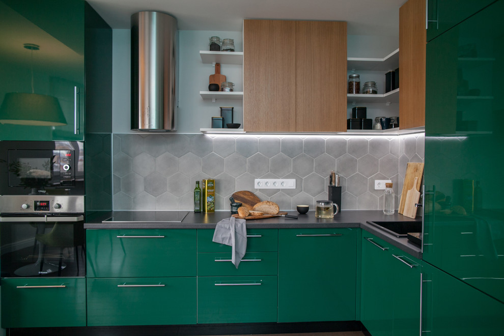 Mid-sized contemporary l-shaped eat-in kitchen in Yekaterinburg with a single-bowl sink, flat-panel cabinets, green cabinets, laminate benchtops, grey splashback, porcelain splashback, stainless steel appliances, laminate floors, no island, brown floor and grey benchtop.