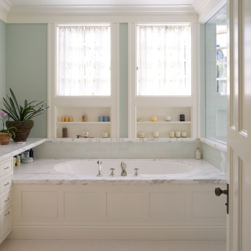 Photo of a traditional master bathroom in San Francisco with white cabinets, an alcove tub, blue tile, subway tile and white floor.
