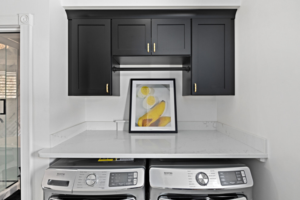 This is an example of a small contemporary single-wall dedicated laundry room in Other with recessed-panel cabinets, black cabinets, quartzite benchtops, a side-by-side washer and dryer and white benchtop.
