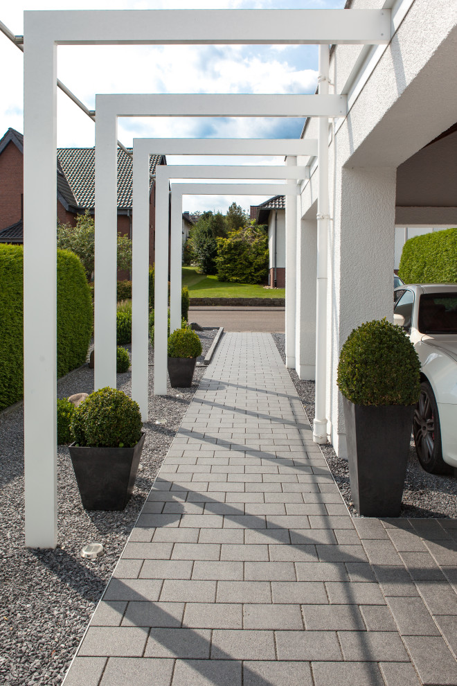 Inspiration for a modern front yard garden with with path and concrete pavers.