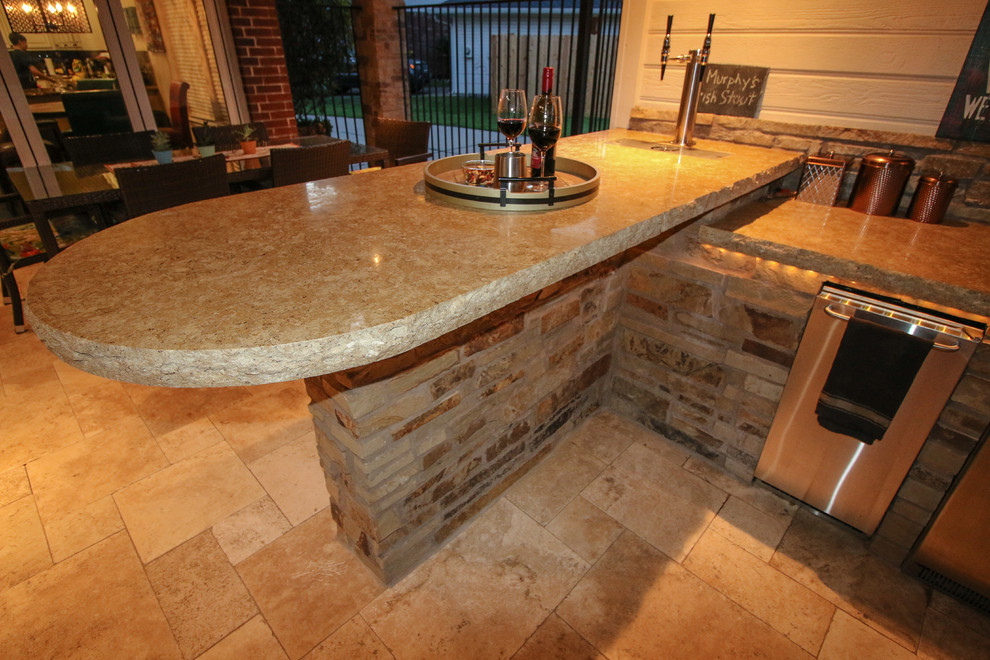 Inspiration for a traditional backyard patio in Houston with an outdoor kitchen and natural stone pavers.