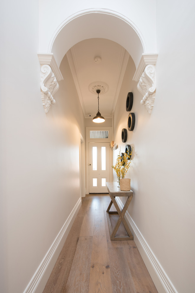 Inspiration for a large transitional hallway in Melbourne with white walls and light hardwood floors.