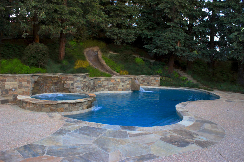 Photo of a large transitional backyard custom-shaped natural pool in San Francisco with a water slide and concrete slab.