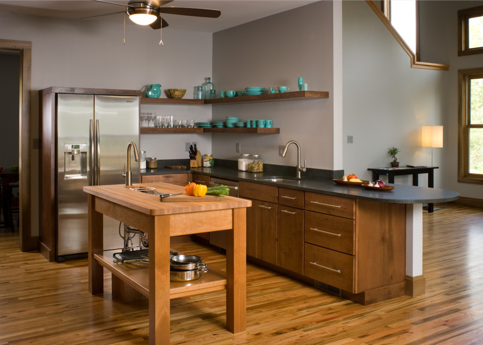 Inspiration for a mid-sized transitional l-shaped medium tone wood floor and brown floor kitchen remodel with an undermount sink, flat-panel cabinets, medium tone wood cabinets, stainless steel appliances and an island