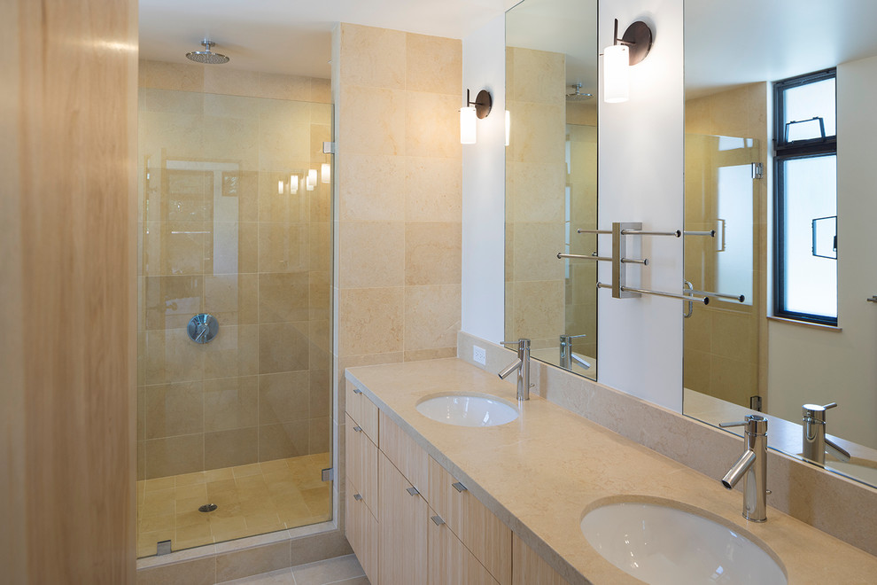 Photo of a large contemporary master bathroom in San Francisco with flat-panel cabinets, light wood cabinets, an alcove shower, beige tile, porcelain tile, beige walls, porcelain floors, an undermount sink and limestone benchtops.