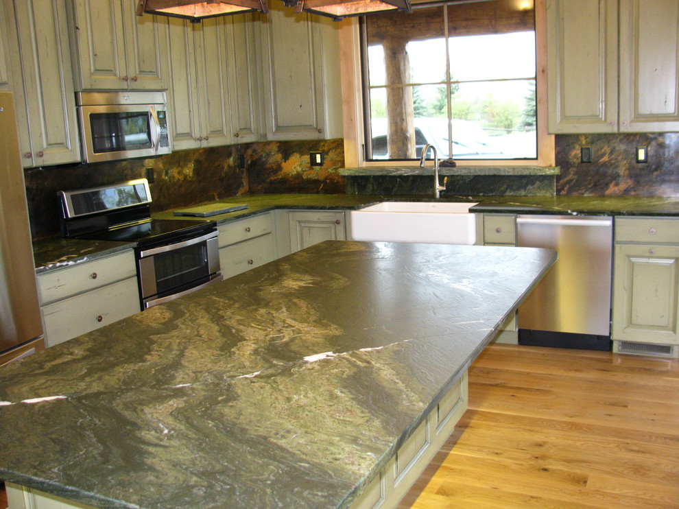Eat-in kitchen - medium tone wood floor eat-in kitchen idea with a farmhouse sink, granite countertops, stone slab backsplash, stainless steel appliances and an island