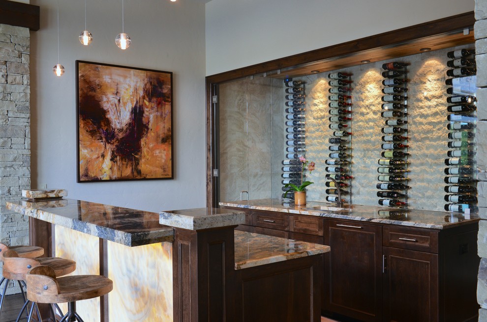 Photo of a large transitional galley seated home bar in Dallas with an undermount sink, recessed-panel cabinets, dark wood cabinets, beige splashback and multi-coloured benchtop.