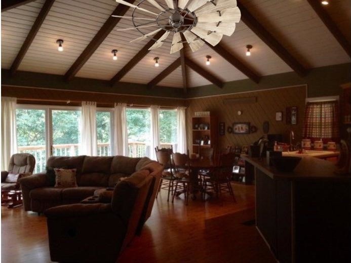 Large mountain style open concept medium tone wood floor home design photo in Orange County with a bar and brown walls