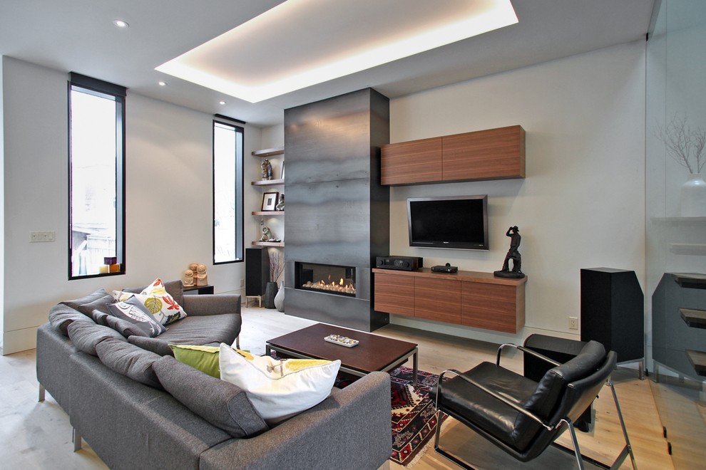 Inspiration for a contemporary open concept family room in Toronto with white walls, light hardwood floors, a ribbon fireplace, a metal fireplace surround and a built-in media wall.