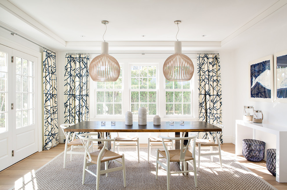 Inspiration for a beach style dining room in Boston with white walls and light hardwood floors.