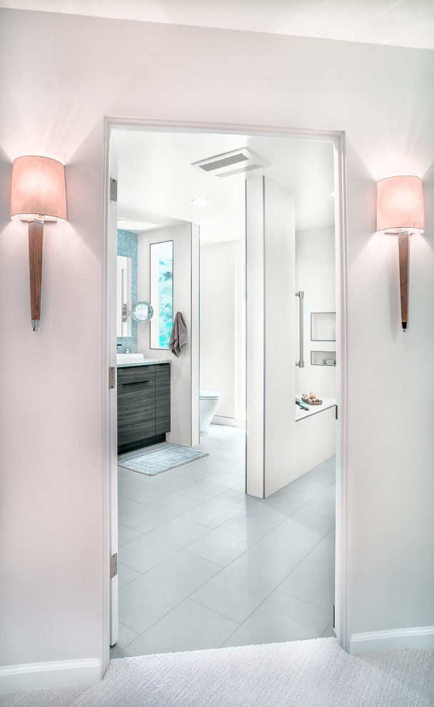 Photo of a large modern master bathroom in San Francisco with a curbless shower, a one-piece toilet, white tile, porcelain tile, white walls, porcelain floors, a vessel sink, flat-panel cabinets and dark wood cabinets.