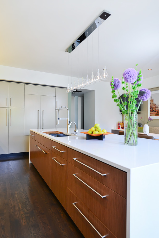 Photo of a large contemporary l-shaped open plan kitchen in Chicago with an undermount sink, flat-panel cabinets, medium wood cabinets, quartz benchtops, white splashback, stainless steel appliances, dark hardwood floors and with island.