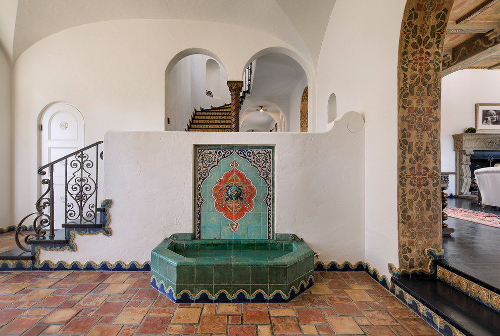 Example of a large tuscan ceramic tile and orange floor foyer design in Santa Barbara with white walls