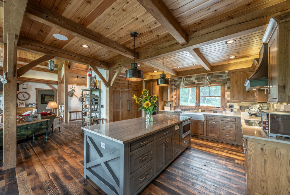 Inspiration for a mid-sized country u-shaped eat-in kitchen in Milwaukee with a farmhouse sink, beaded inset cabinets, distressed cabinets, quartzite benchtops, brown splashback, ceramic splashback, panelled appliances, dark hardwood floors, with island, brown floor and grey benchtop.