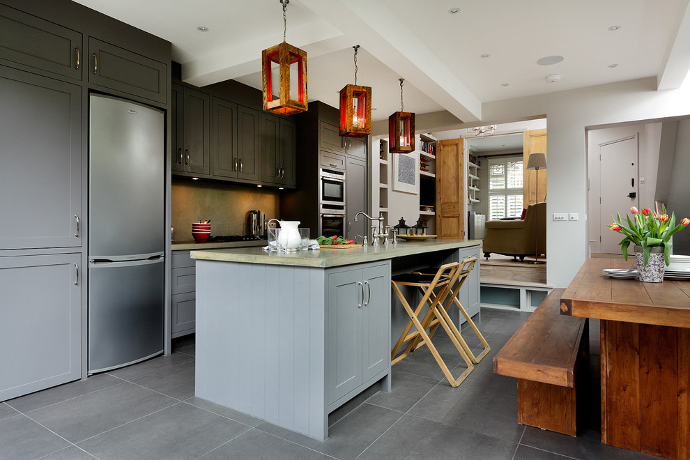 This is an example of a contemporary single-wall eat-in kitchen in London with shaker cabinets, grey cabinets, stainless steel appliances, porcelain floors, with island, concrete benchtops and grey floor.