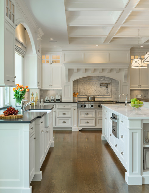 Bright classic kitchen with white Shaker RTA cabinets, a large island, coffered ceiling, and stainless range on warm wood floors.