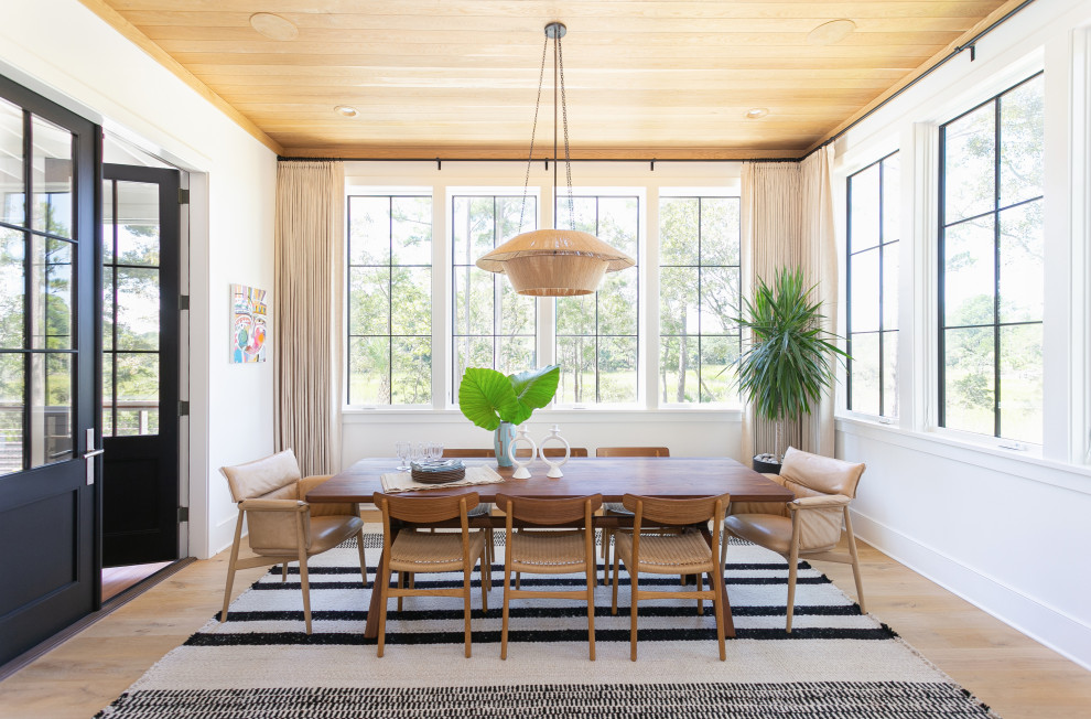 Foto di una sala da pranzo aperta verso il soggiorno tradizionale con pareti bianche, pavimento in legno massello medio, pavimento marrone e soffitto in legno