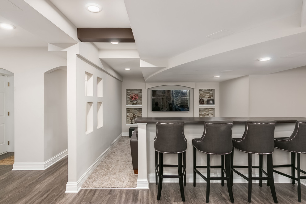 Inspiration for a large transitional fully buried basement in Chicago with white walls, vinyl floors, no fireplace and brown floor.