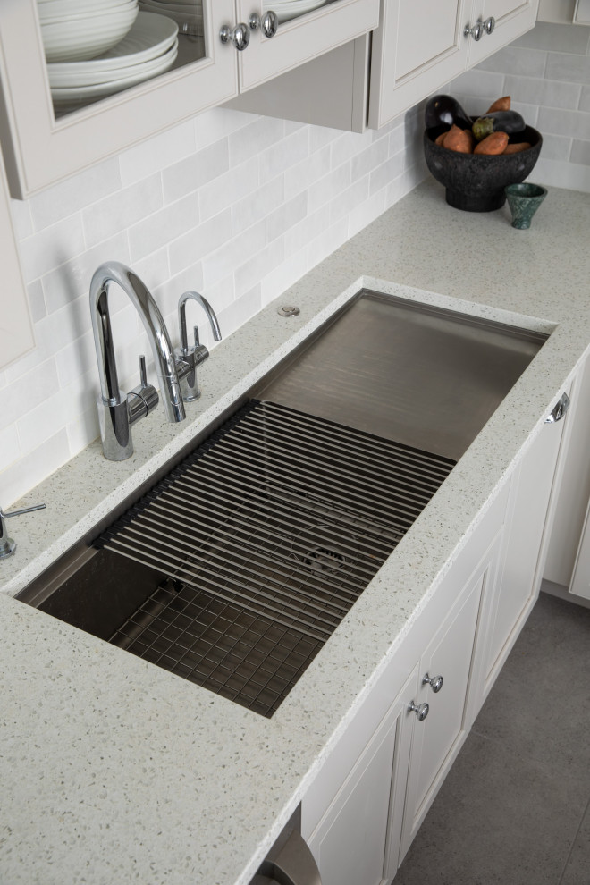Inspiration for a huge porcelain tile and gray floor kitchen remodel with a drop-in sink, recessed-panel cabinets, white backsplash, ceramic backsplash, stainless steel appliances and white countertops