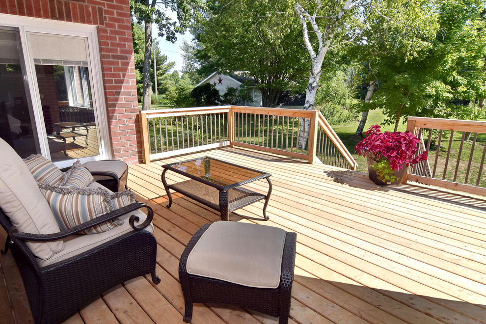 Example of a mid-sized transitional backyard deck design in Toronto with a roof extension