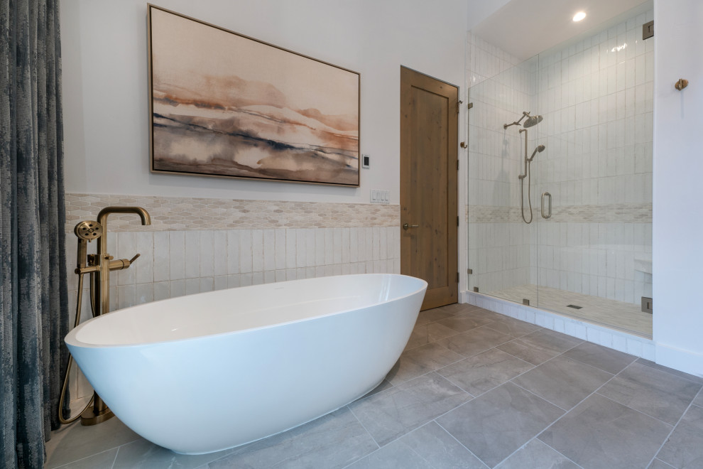 Example of a transitional ceramic tile porcelain tile and beige floor freestanding bathtub design with white walls and a hinged shower door