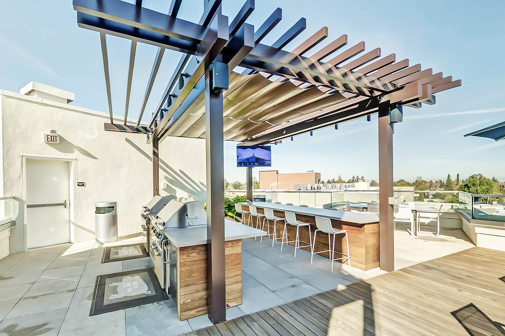 Modern rooftop deck in San Francisco with an outdoor kitchen and a pergola.
