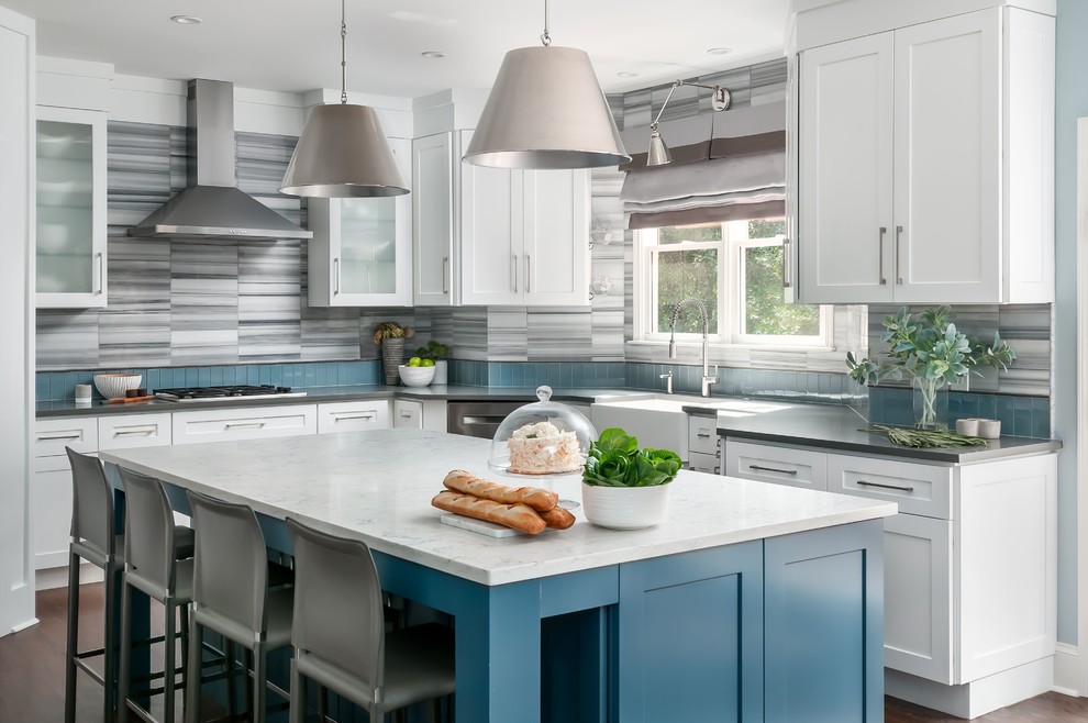 This is an example of a beach style l-shaped kitchen in Atlanta with a farmhouse sink, shaker cabinets, white cabinets, multi-coloured splashback, dark hardwood floors, with island, brown floor and grey benchtop.