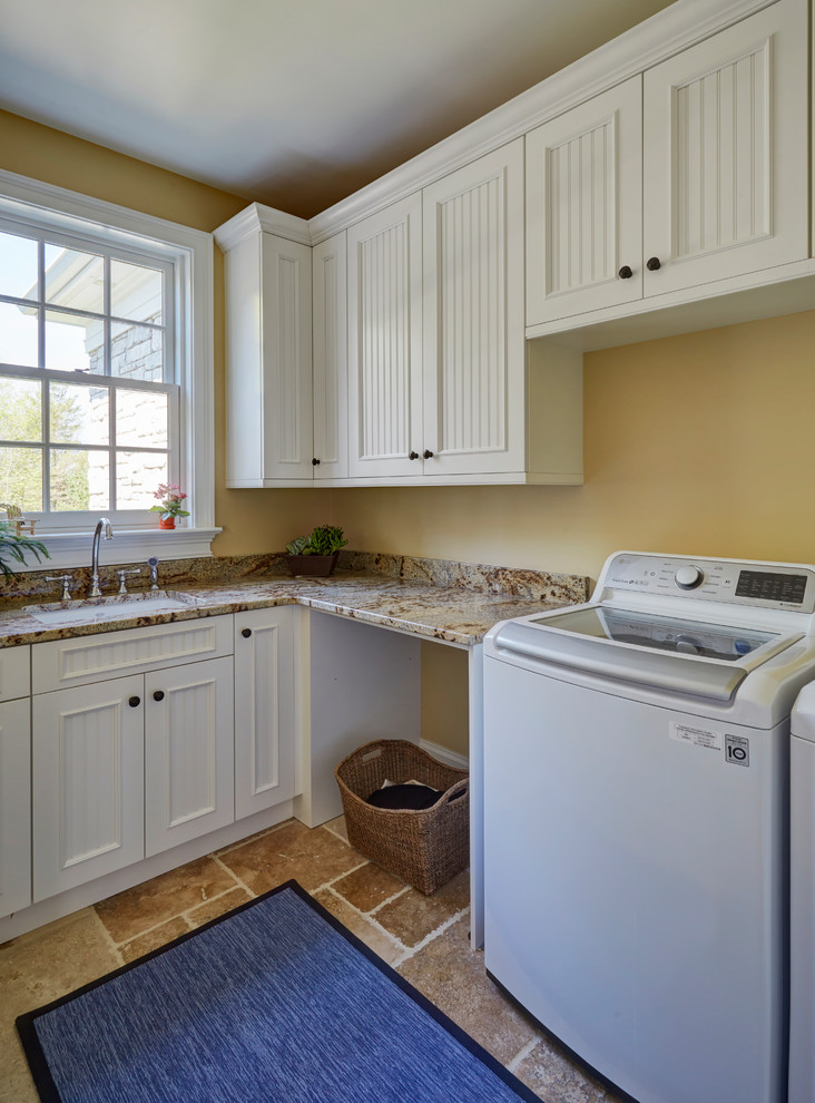 Design ideas for a small traditional u-shaped dedicated laundry room in Milwaukee with an undermount sink, beaded inset cabinets, white cabinets, granite benchtops, yellow walls, limestone floors, a side-by-side washer and dryer, brown floor and multi-coloured benchtop.