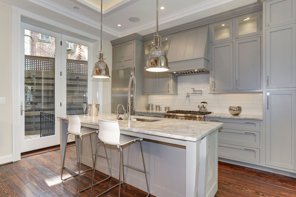 Example of a classic galley dark wood floor kitchen design in DC Metro with an undermount sink, gray cabinets, quartzite countertops, glass tile backsplash, shaker cabinets, white backsplash, stainless steel appliances and an island