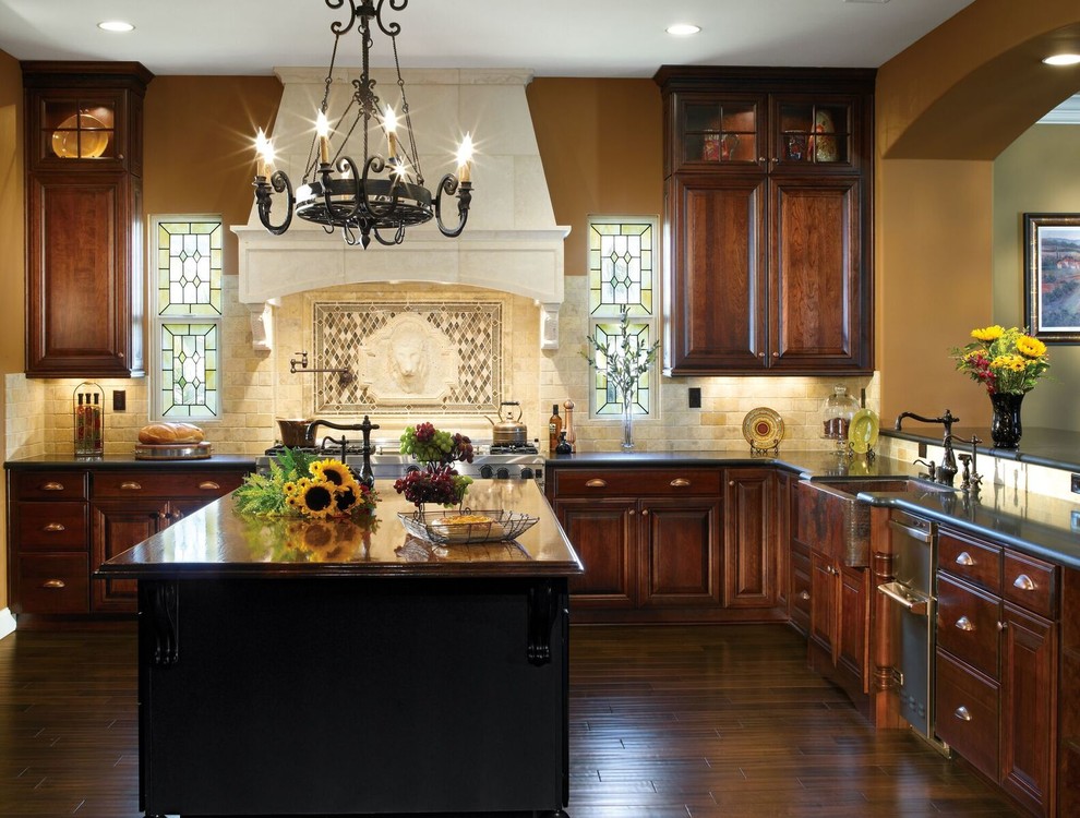 Enclosed kitchen - mid-sized rustic l-shaped dark wood floor and brown floor enclosed kitchen idea with a farmhouse sink, raised-panel cabinets, dark wood cabinets, granite countertops, beige backsplash, porcelain backsplash, stainless steel appliances and an island