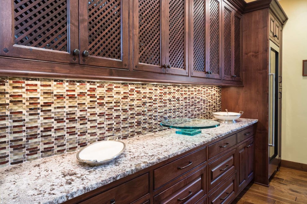 Inspiration for a large rustic galley medium tone wood floor kitchen pantry remodel with beaded inset cabinets, dark wood cabinets, granite countertops, multicolored backsplash, glass tile backsplash, stainless steel appliances and no island