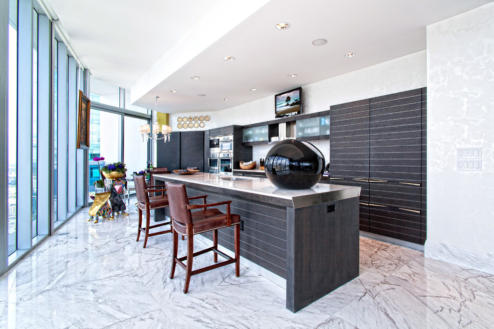 Large transitional single-wall marble floor and white floor enclosed kitchen photo in Miami with an undermount sink, flat-panel cabinets, black cabinets, marble countertops, gray backsplash, stone slab backsplash and an island