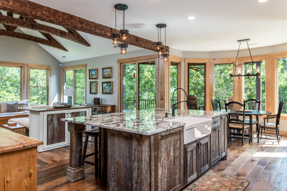Inspiration for a mid-sized rustic l-shaped medium tone wood floor and brown floor enclosed kitchen remodel with a farmhouse sink, recessed-panel cabinets, white cabinets, granite countertops, white backsplash, subway tile backsplash, paneled appliances, an island and multicolored countertops