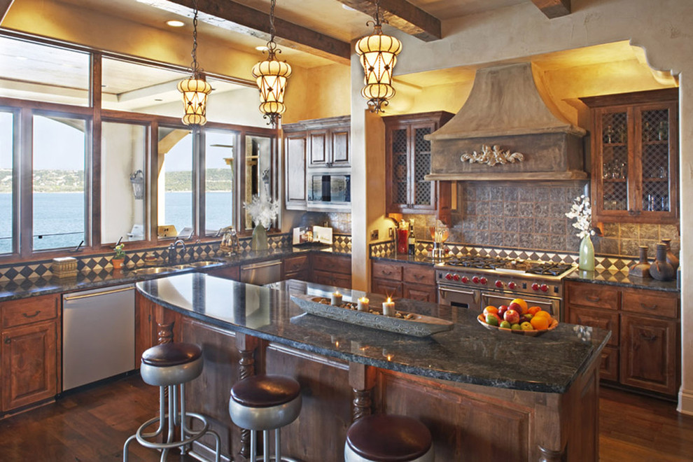 Mediterrane Küche mit Küchengeräten aus Edelstahl, Triple-Waschtisch, profilierten Schrankfronten und dunklen Holzschränken in Austin