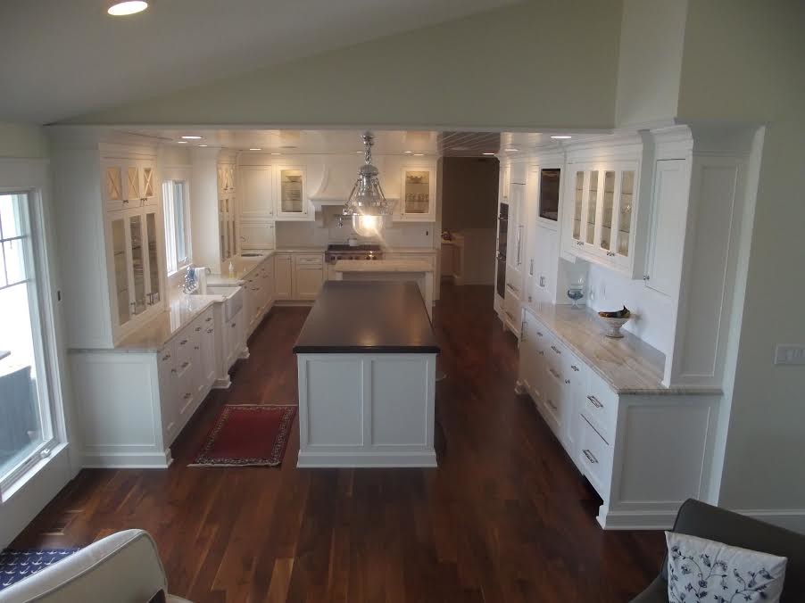 Mid-sized transitional u-shaped medium tone wood floor open concept kitchen photo with recessed-panel cabinets, white cabinets, white appliances and an island