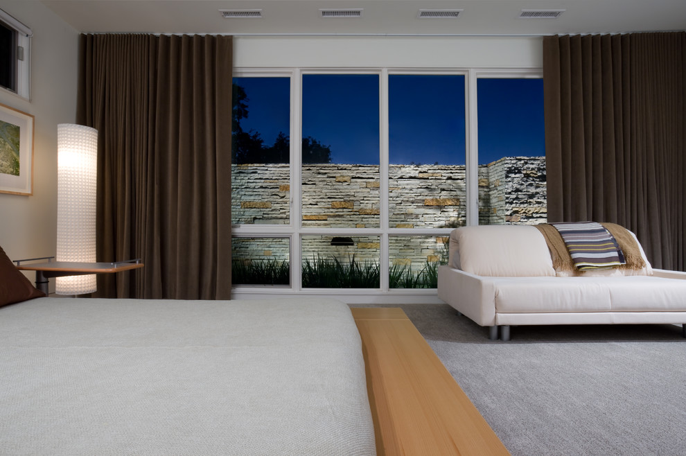 This is an example of a mid-sized contemporary master bedroom in Dallas with white walls and carpet.