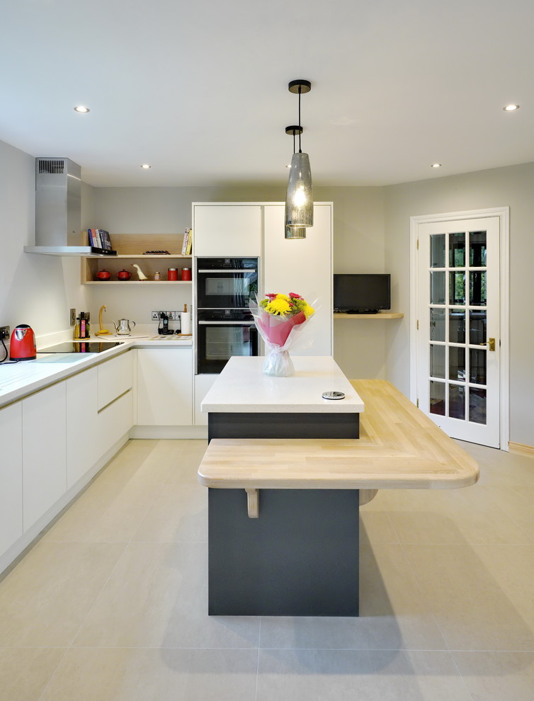 This is an example of a mid-sized contemporary l-shaped kitchen in Other with flat-panel cabinets, white cabinets, with island and beige floor.