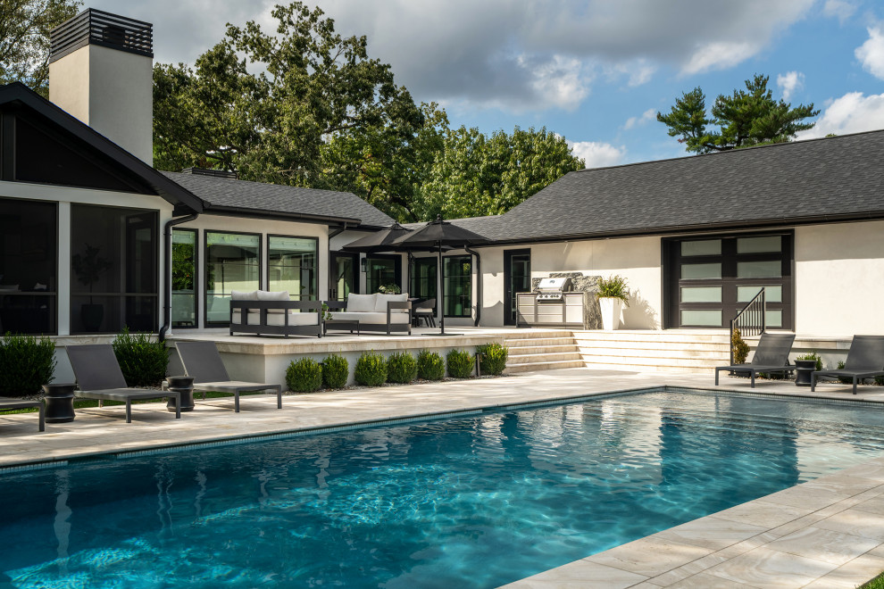 Example of a large classic backyard rectangular pool design in Other
