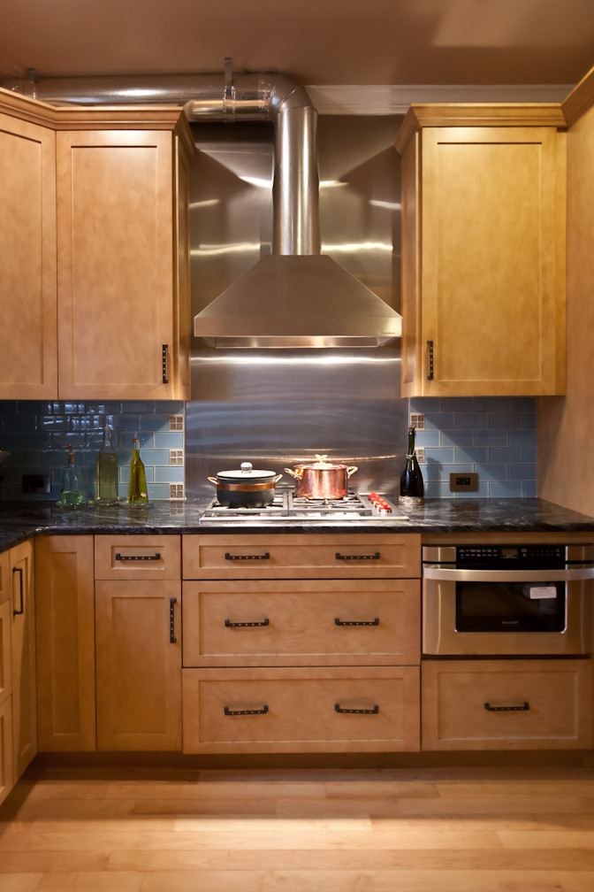 Stove with custom cabinetry, glass tile and steel backsplash