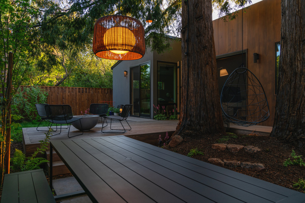 Photo of a small modern partial sun backyard wood fence landscaping in San Francisco with decking and a fire pit.