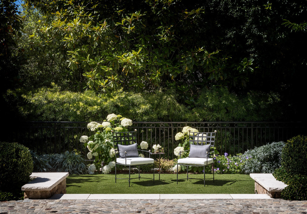 Exemple d'un jardin à la française arrière avec une exposition partiellement ombragée, des pavés en pierre naturelle et une clôture en métal.