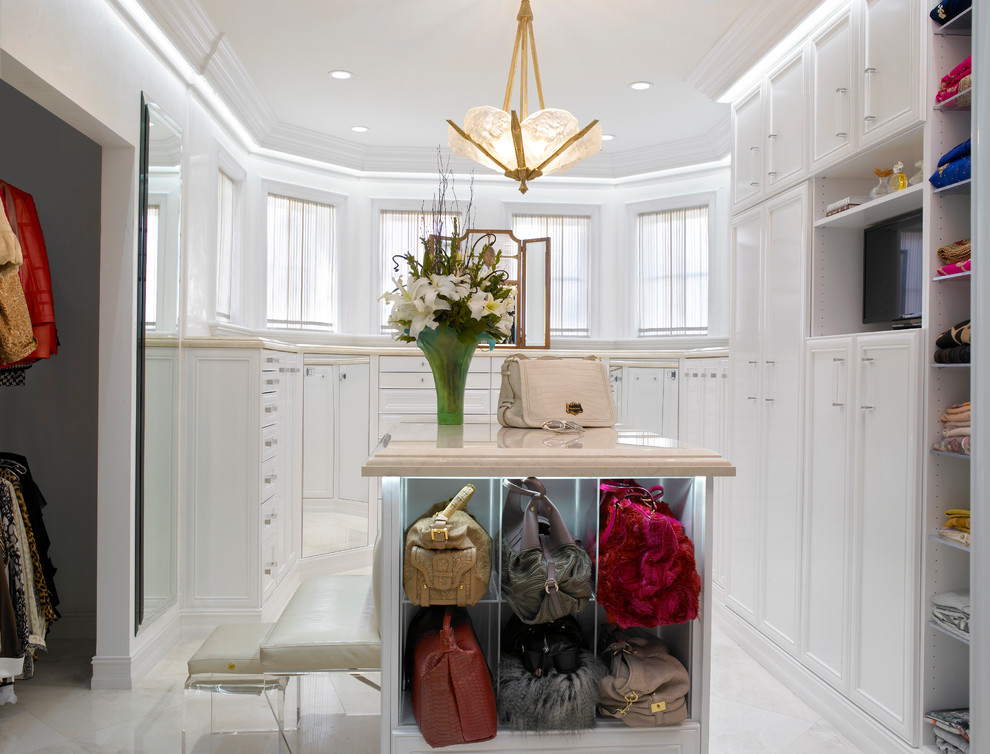Large traditional gender-neutral walk-in wardrobe in Miami with recessed-panel cabinets, white cabinets, marble floors and white floor.