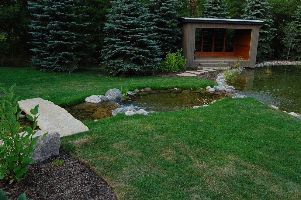 This is an example of a contemporary backyard garden in Toronto with a water feature.