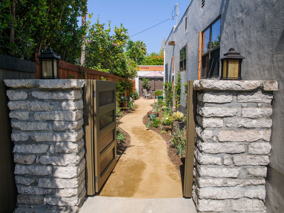 This is an example of a mid-sized modern side yard partial sun formal garden in Los Angeles with a garden path and gravel.