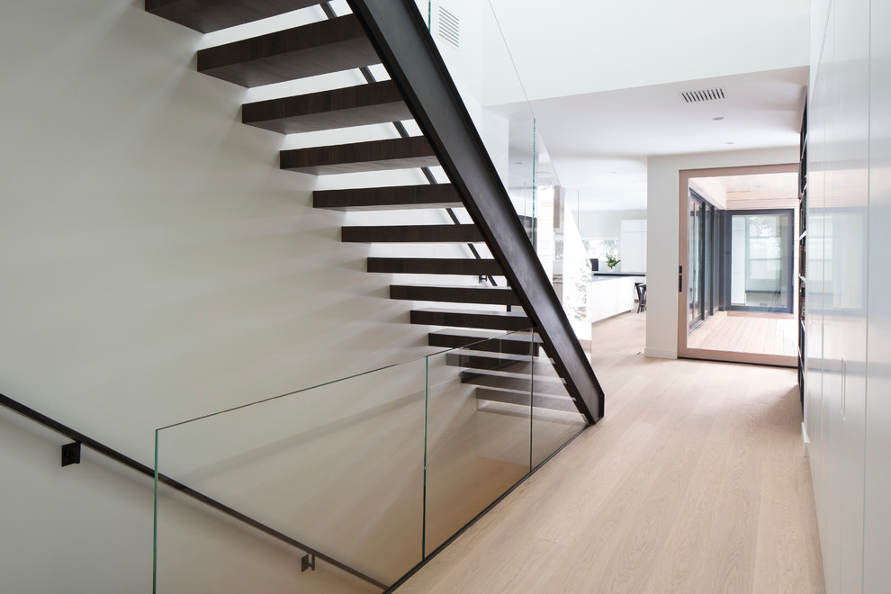 Example of a danish wooden floating staircase design in Salt Lake City with metal risers