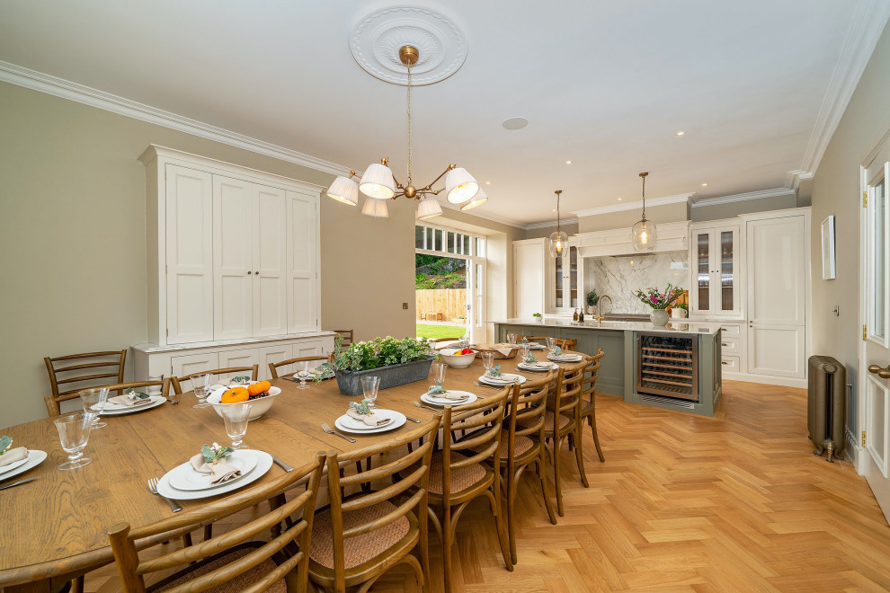 Immagine di una grande cucina chic con ante a filo, ante bianche, paraspruzzi bianco, pavimento marrone e top bianco