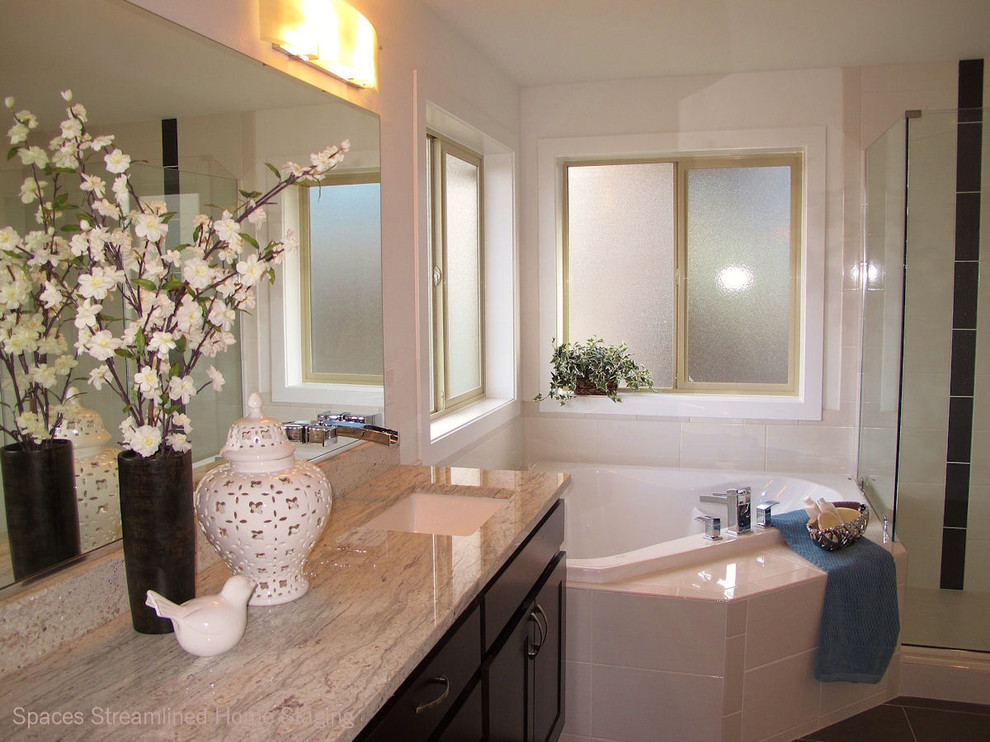 Large transitional master white tile and ceramic tile porcelain tile corner bathtub photo in Seattle with an undermount sink, recessed-panel cabinets, dark wood cabinets, granite countertops and white walls