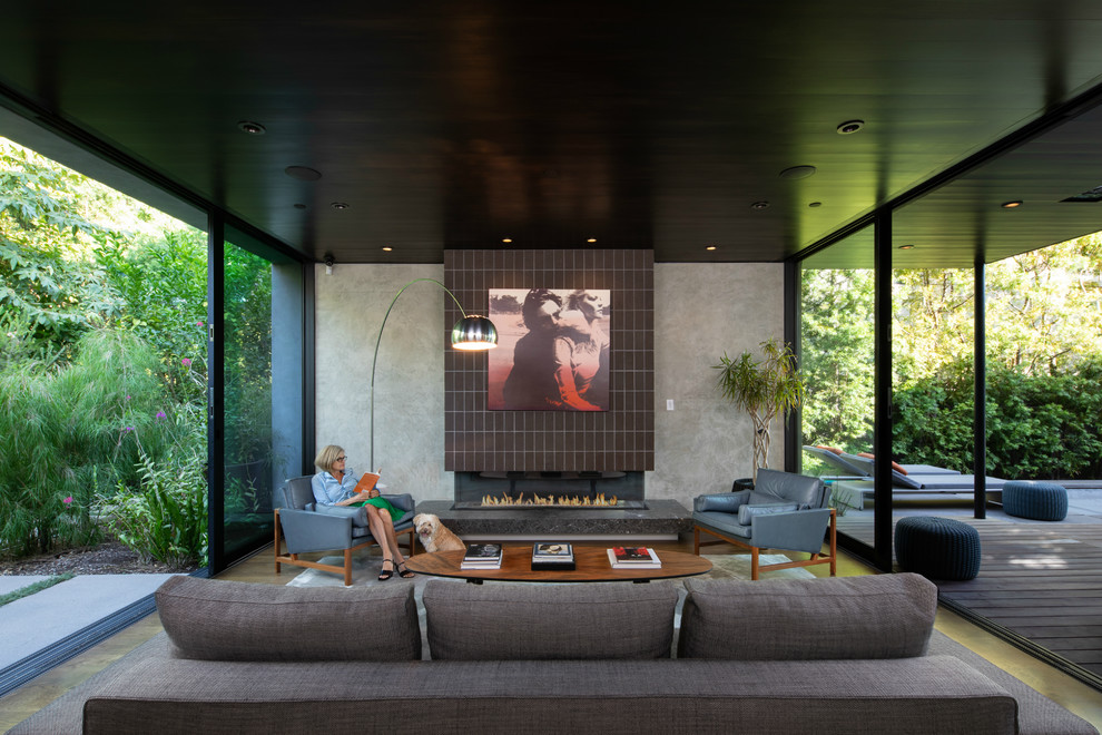 This is an example of a contemporary living room in Los Angeles with grey walls, dark hardwood floors, a ribbon fireplace, a brick fireplace surround and brown floor.