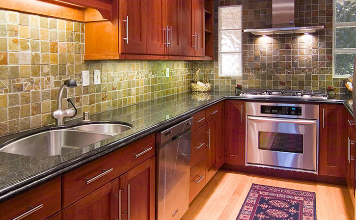Enclosed kitchen - mid-sized contemporary u-shaped enclosed kitchen idea with a double-bowl sink, recessed-panel cabinets, dark wood cabinets, green backsplash, stainless steel appliances, granite countertops and no island