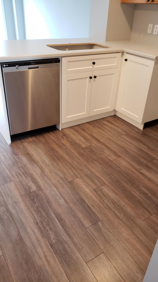 Inspiration for a transitional u-shaped open concept kitchen remodel with an undermount sink, shaker cabinets, white cabinets, laminate countertops and gray backsplash
